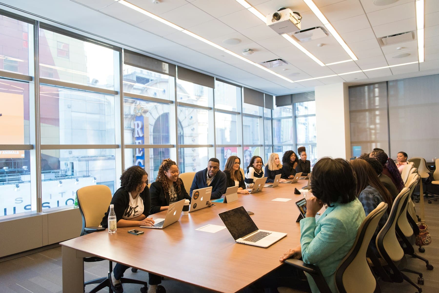 Reunión de trabajo en una sala corporativa con ventanales y luz de día.