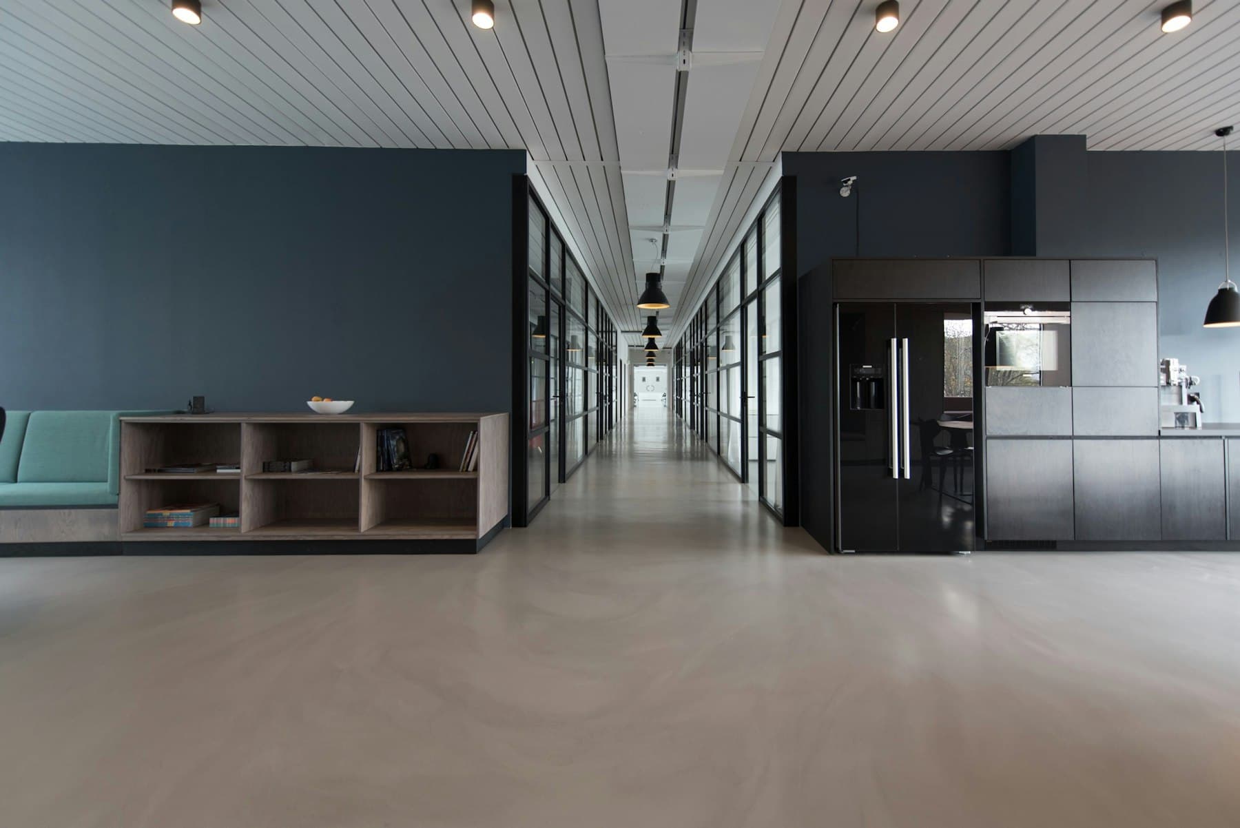 Pasillo de oficinas contemporáneo en tonos grises y azules.